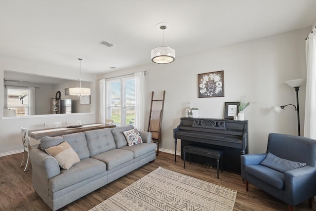 living area with visible vents, baseboards, and wood finished floors