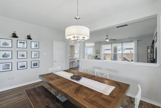 dining area featuring ceiling fan with notable chandelier, baseboards, visible vents, and dark wood-style flooring