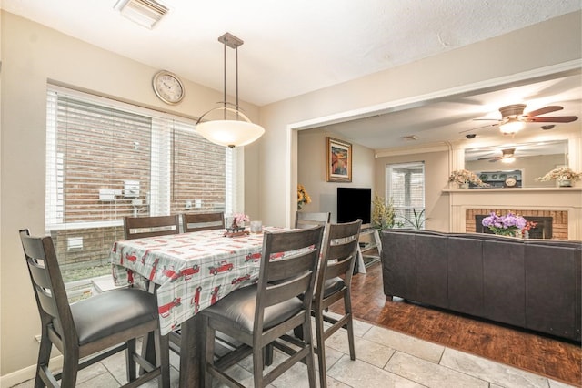 dining area featuring tile patterned floors, visible vents, and a fireplace