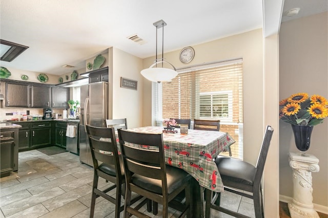 dining space with baseboards, visible vents, and light wood-type flooring