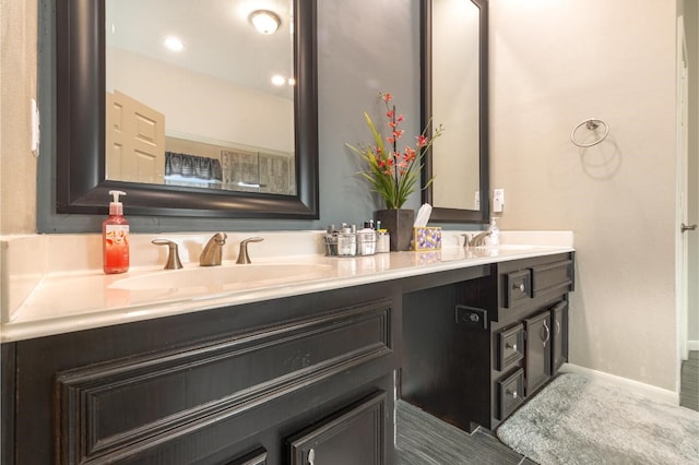 bathroom featuring a sink, baseboards, and double vanity