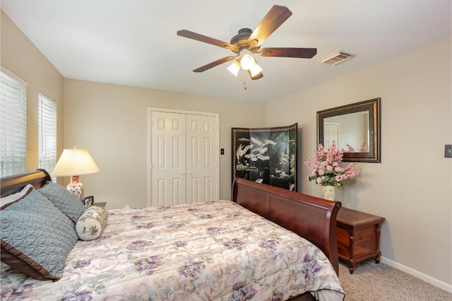 bedroom with baseboards, visible vents, carpet floors, ceiling fan, and a closet