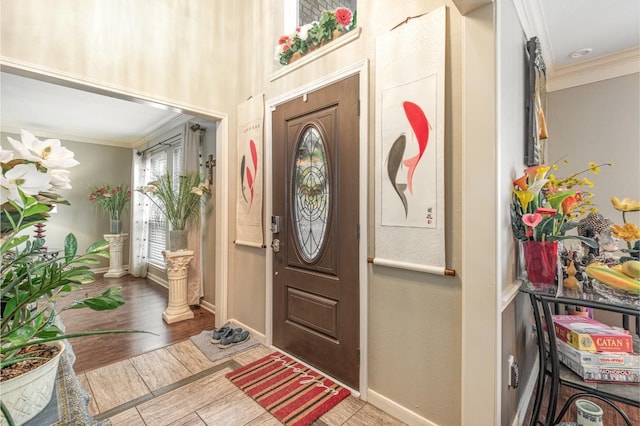 foyer with crown molding, baseboards, and wood finished floors