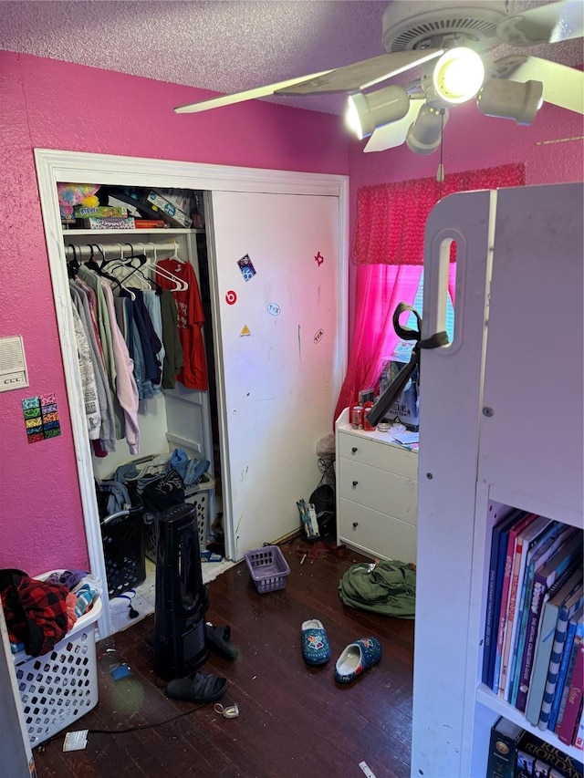 bedroom featuring a closet, a textured ceiling, a textured wall, and wood-type flooring