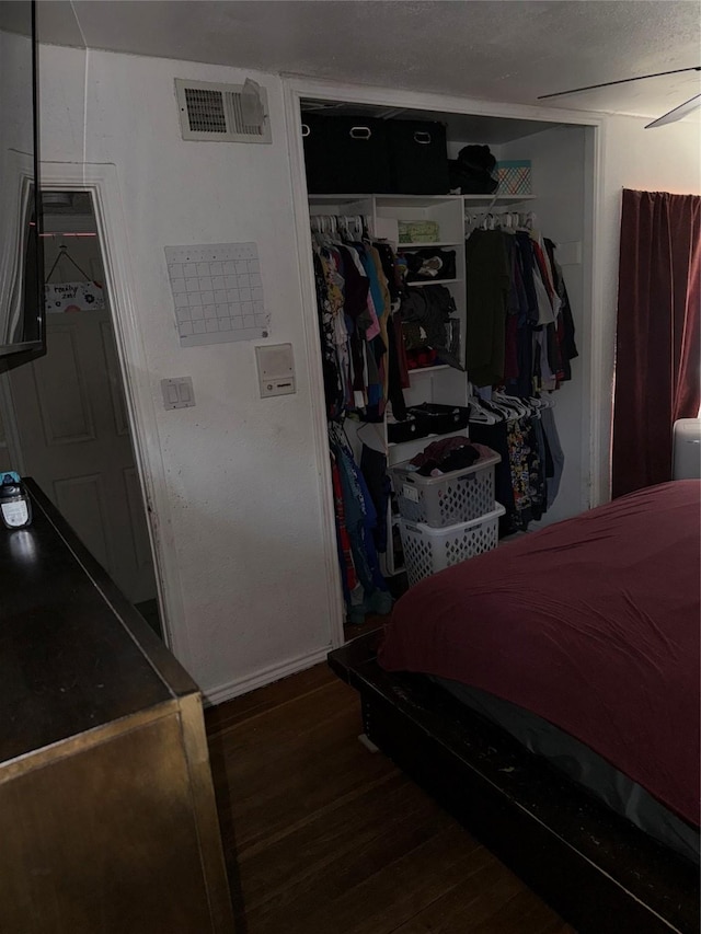 bedroom featuring visible vents, a closet, and wood finished floors