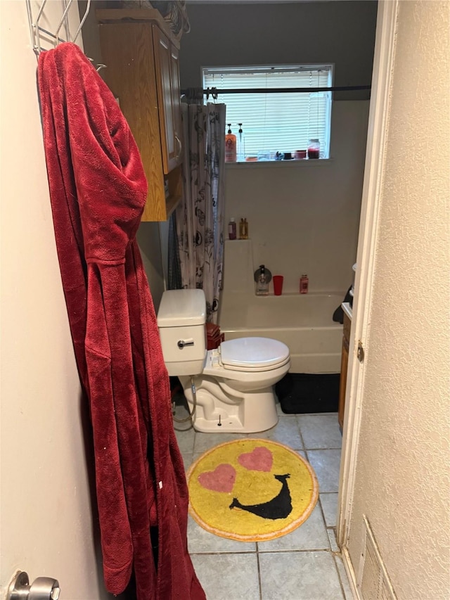 full bathroom featuring tile patterned floors, toilet, and shower / bath combo with shower curtain