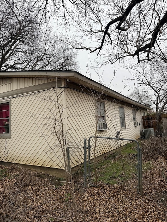 view of side of property featuring cooling unit and fence