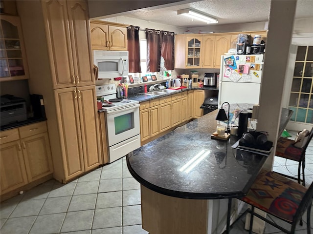 kitchen featuring white appliances, light tile patterned floors, glass insert cabinets, a textured ceiling, and dark countertops