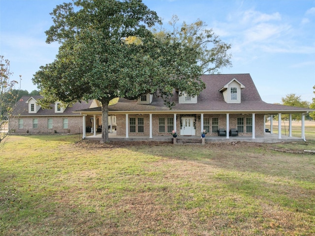 view of front of property featuring brick siding, a front yard, and a patio area