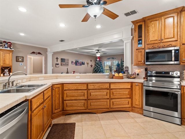 kitchen with visible vents, a sink, appliances with stainless steel finishes, decorative backsplash, and ornate columns