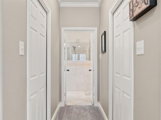 hallway with baseboards, light carpet, and ornamental molding