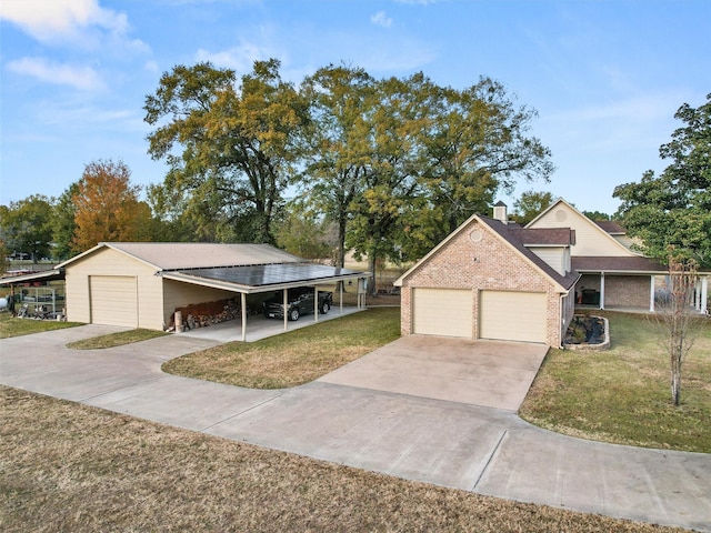 view of front of property with a front lawn, a garage, brick siding, and a chimney