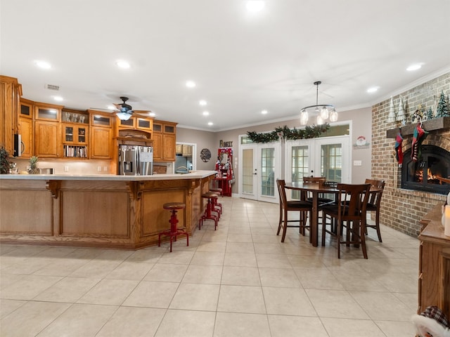 kitchen with brown cabinetry, stainless steel fridge with ice dispenser, french doors, and ornamental molding