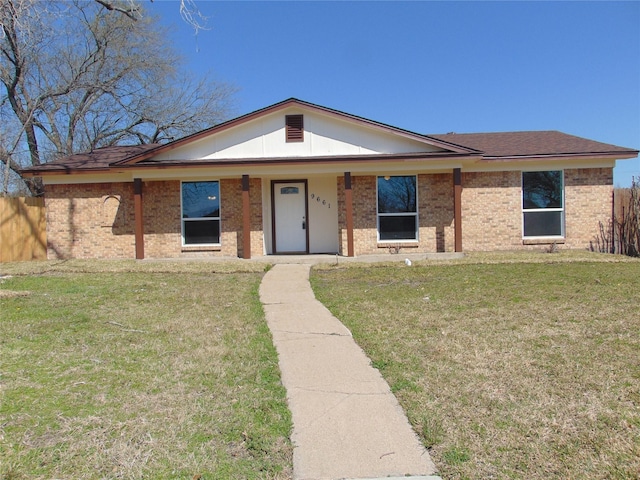 view of front of home with brick siding, a front yard, and fence