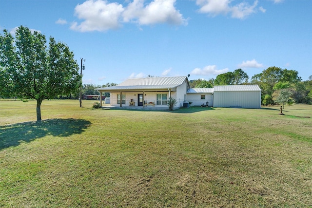 rear view of house with metal roof and a yard