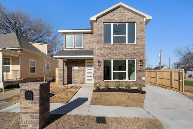 view of front of home featuring fence and brick siding