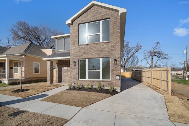 modern home featuring fence and brick siding