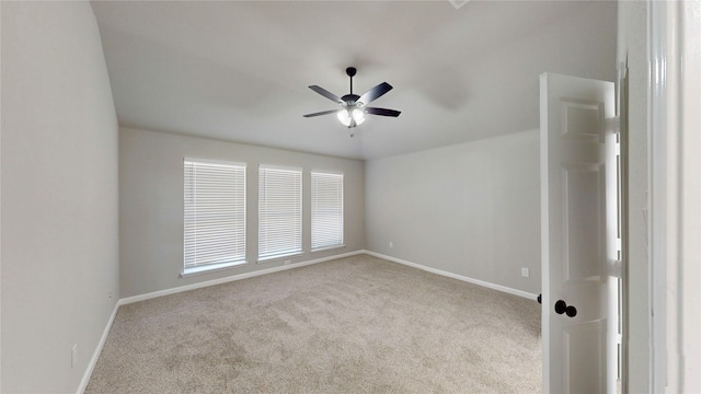 carpeted spare room with baseboards and a ceiling fan