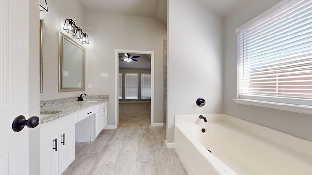 bathroom featuring baseboards, vanity, and a garden tub