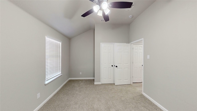 unfurnished bedroom with baseboards, light colored carpet, lofted ceiling, and ceiling fan