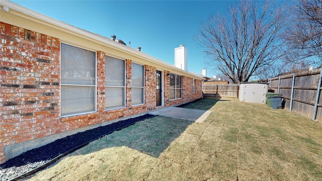 view of yard with a patio, an outdoor structure, and a fenced backyard