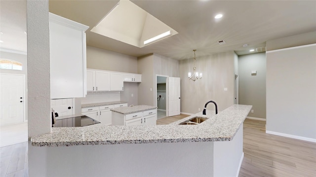 kitchen featuring light wood-style flooring, a sink, range, tasteful backsplash, and a center island