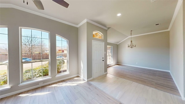 entryway featuring lofted ceiling, light wood-style flooring, baseboards, and ornamental molding