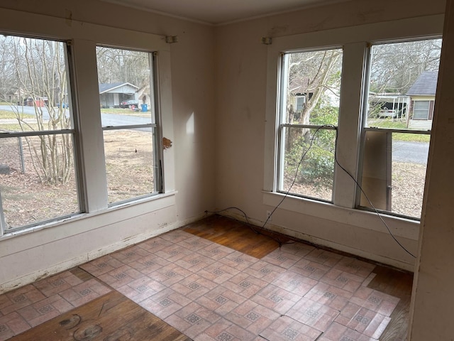 unfurnished room with a healthy amount of sunlight and brick floor