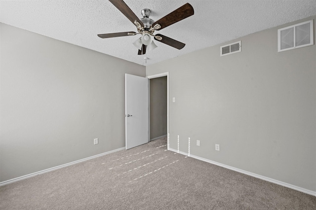 carpeted empty room featuring visible vents, ceiling fan, a textured ceiling, and baseboards