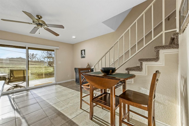 dining space with light tile patterned floors, ceiling fan, stairs, and baseboards