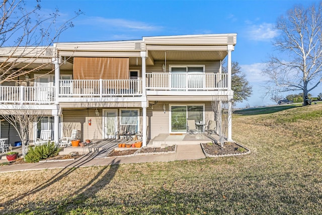 rear view of house featuring a patio and a lawn