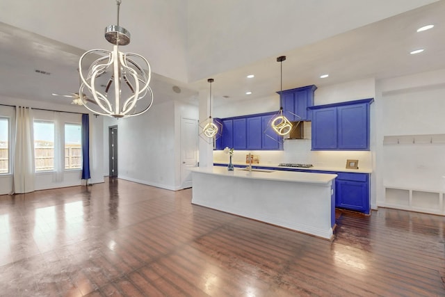 kitchen with an inviting chandelier, blue cabinets, dark wood-style floors, and light countertops