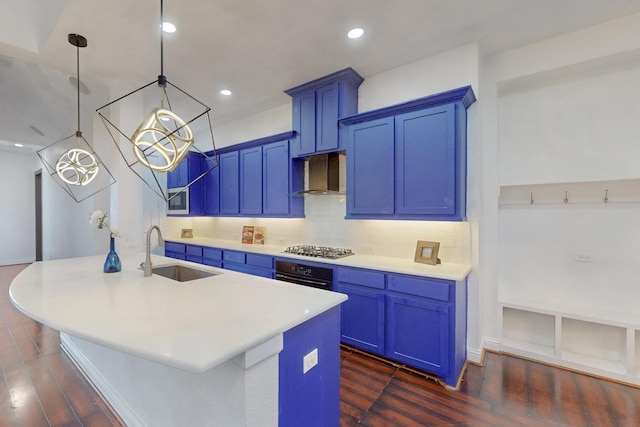 kitchen with a sink, black oven, blue cabinetry, and tasteful backsplash