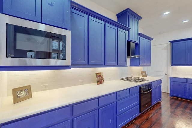 kitchen featuring blue cabinetry, tasteful backsplash, range hood, appliances with stainless steel finishes, and light countertops