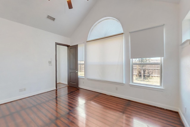 unfurnished room featuring visible vents, baseboards, ceiling fan, vaulted ceiling, and wood finished floors