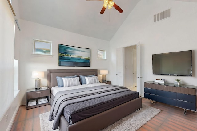 bedroom with baseboards, wood finished floors, visible vents, and high vaulted ceiling