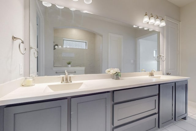 bathroom featuring a sink, double vanity, and a tile shower