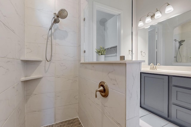 full bathroom with tiled shower and vanity