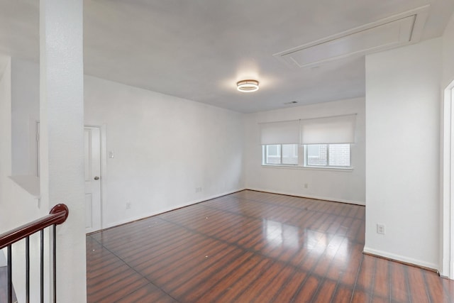 spare room with attic access and wood finished floors