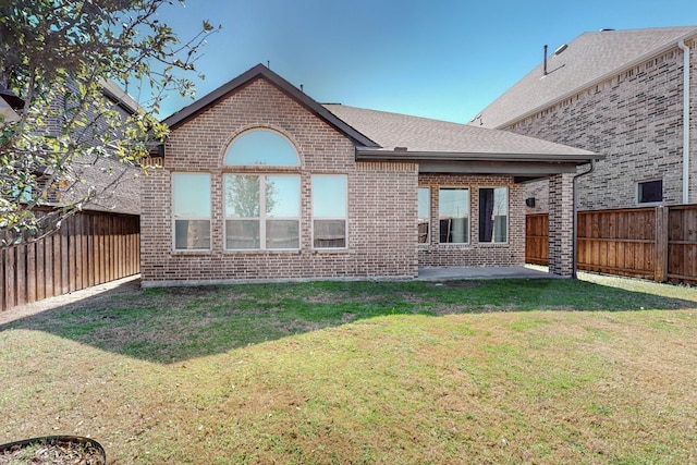 back of house featuring a patio area, a fenced backyard, brick siding, and a lawn