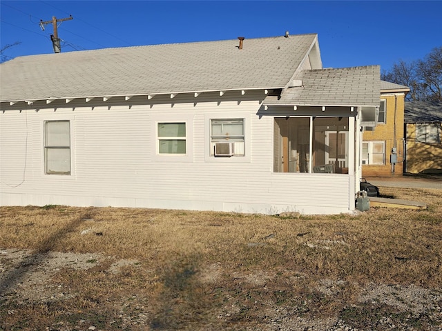 back of house with cooling unit, a shingled roof, and a sunroom