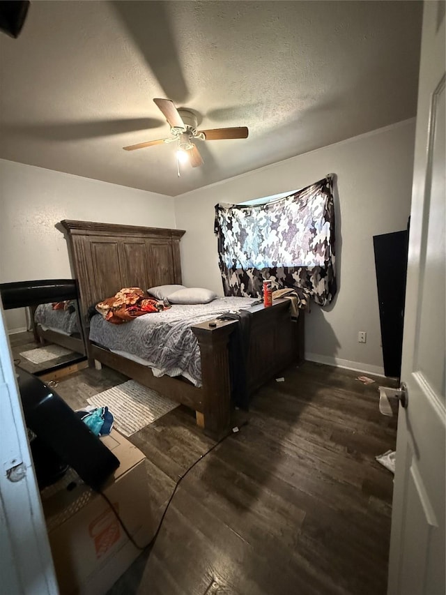 bedroom with dark wood finished floors, ceiling fan, baseboards, and a textured ceiling