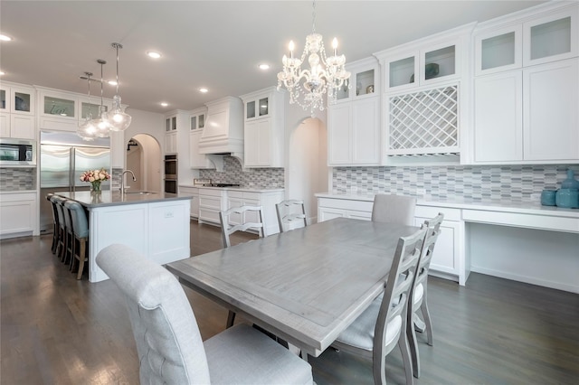 dining space with recessed lighting, arched walkways, and dark wood-type flooring