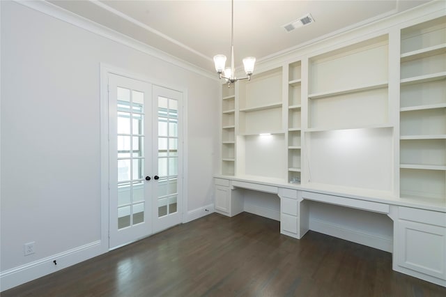 unfurnished office featuring visible vents, dark wood-style floors, built in desk, crown molding, and baseboards