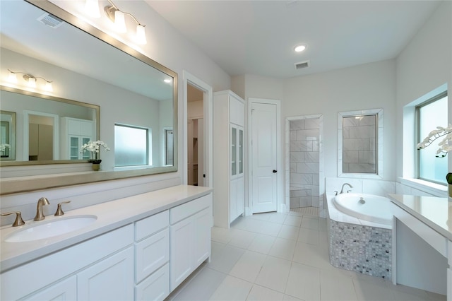 full bath featuring tile patterned floors, visible vents, a garden tub, and vanity