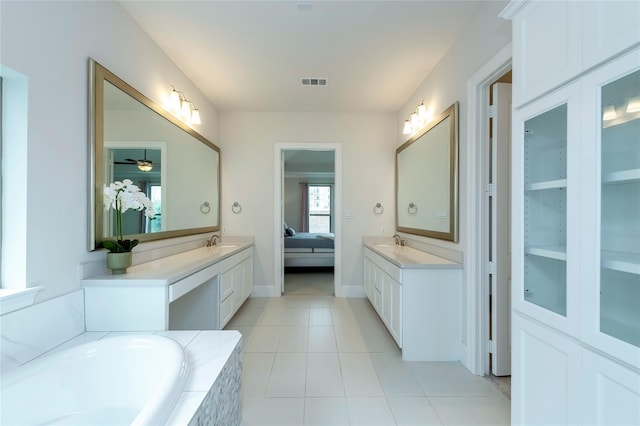 ensuite bathroom featuring visible vents, connected bathroom, two vanities, and a sink