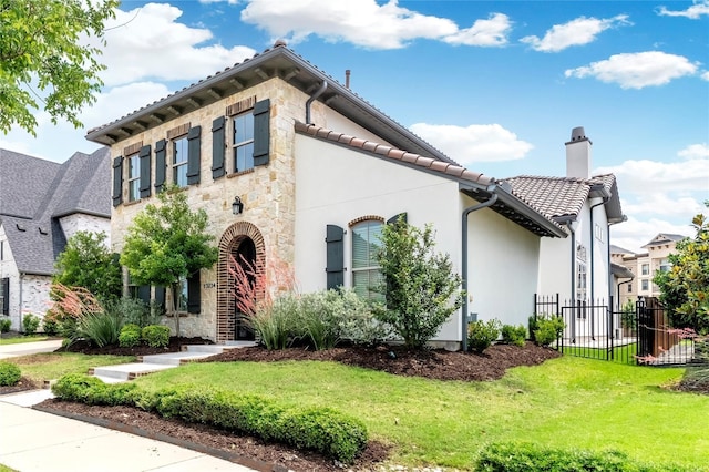 view of front of house featuring stucco siding, stone siding, fence, a front yard, and a chimney