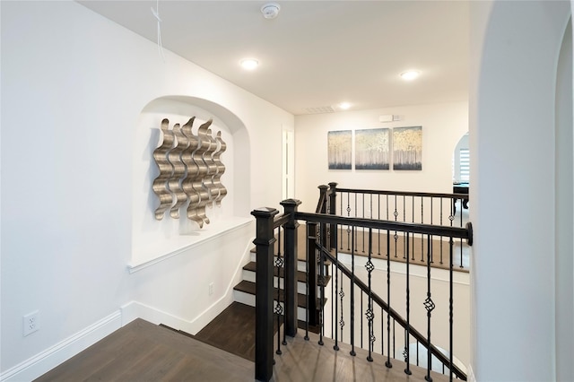 hallway with recessed lighting, baseboards, an upstairs landing, and wood finished floors