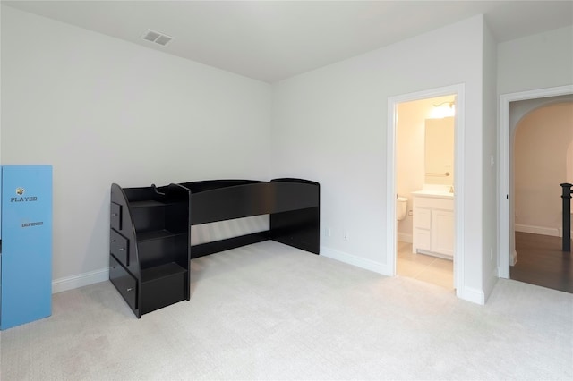 bedroom with arched walkways, visible vents, baseboards, and carpet