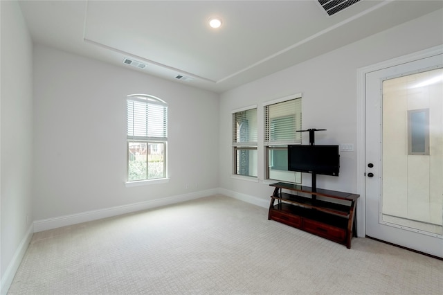 living area featuring visible vents, light colored carpet, and baseboards